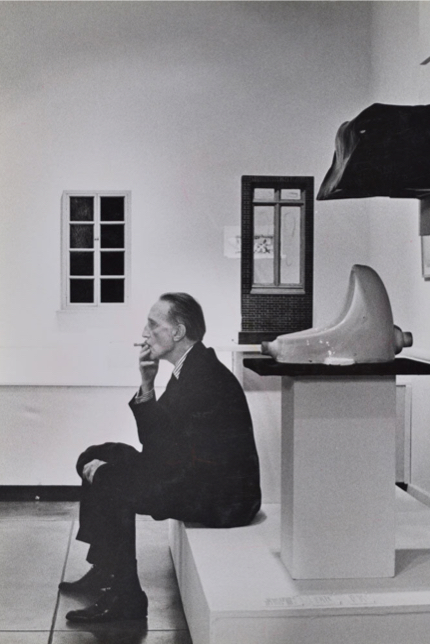 Photograph of Duchamp smoking in front of Fountain